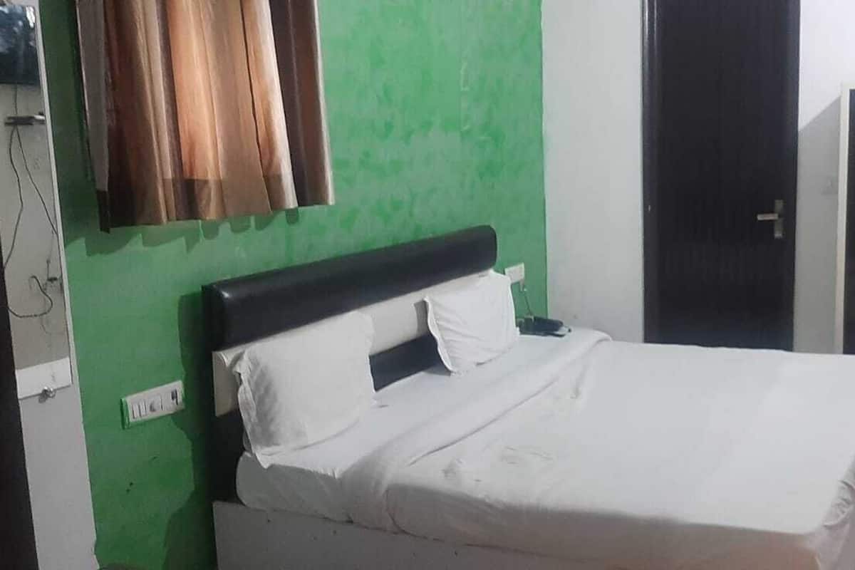 Una habitación con una cama, un armario y una pared verde.