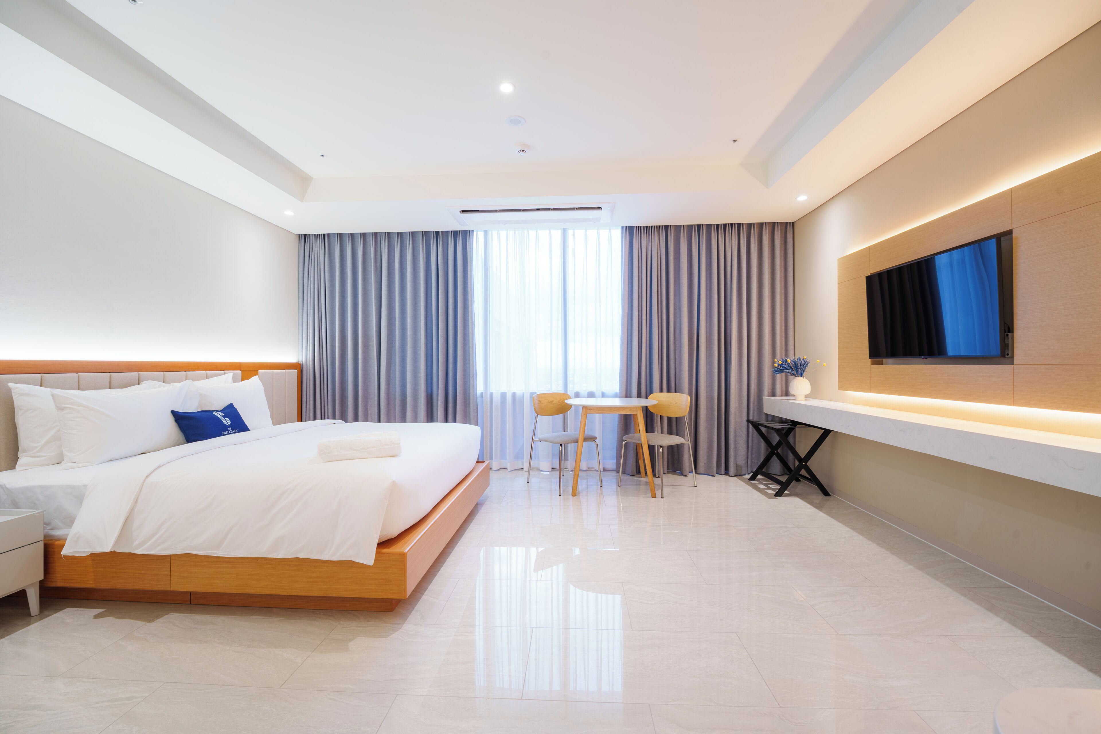 Une chambre d’hôtel moderne équipée d’un grand lit, d’un bureau et d’un téléviseur à écran plat.