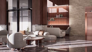 A modern living room with a sofa, armchairs, a coffee table, and a bookshelf.