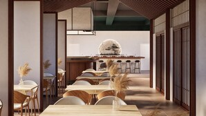 A modern interior with wooden tables and chairs, a central bar area, and decorative plants.