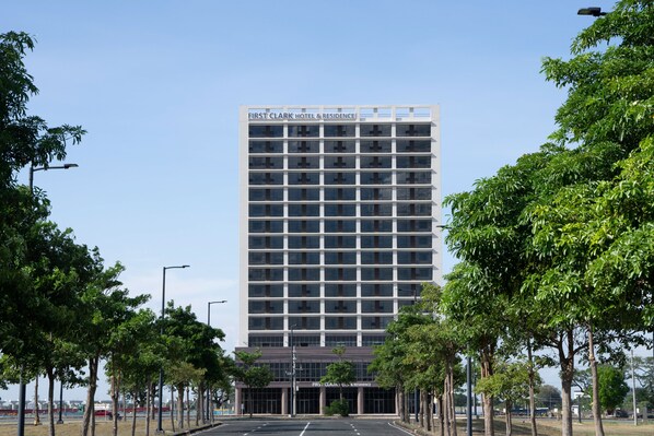 A tall, modern hotel building with a clear sky. - The First Clark Hotel & Residence (Mabalacat City)