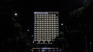 A multi-story hotel building with a grid of windows and a sign reading "FIRST CLARK HOTEL & RESIDENCE" at the top.