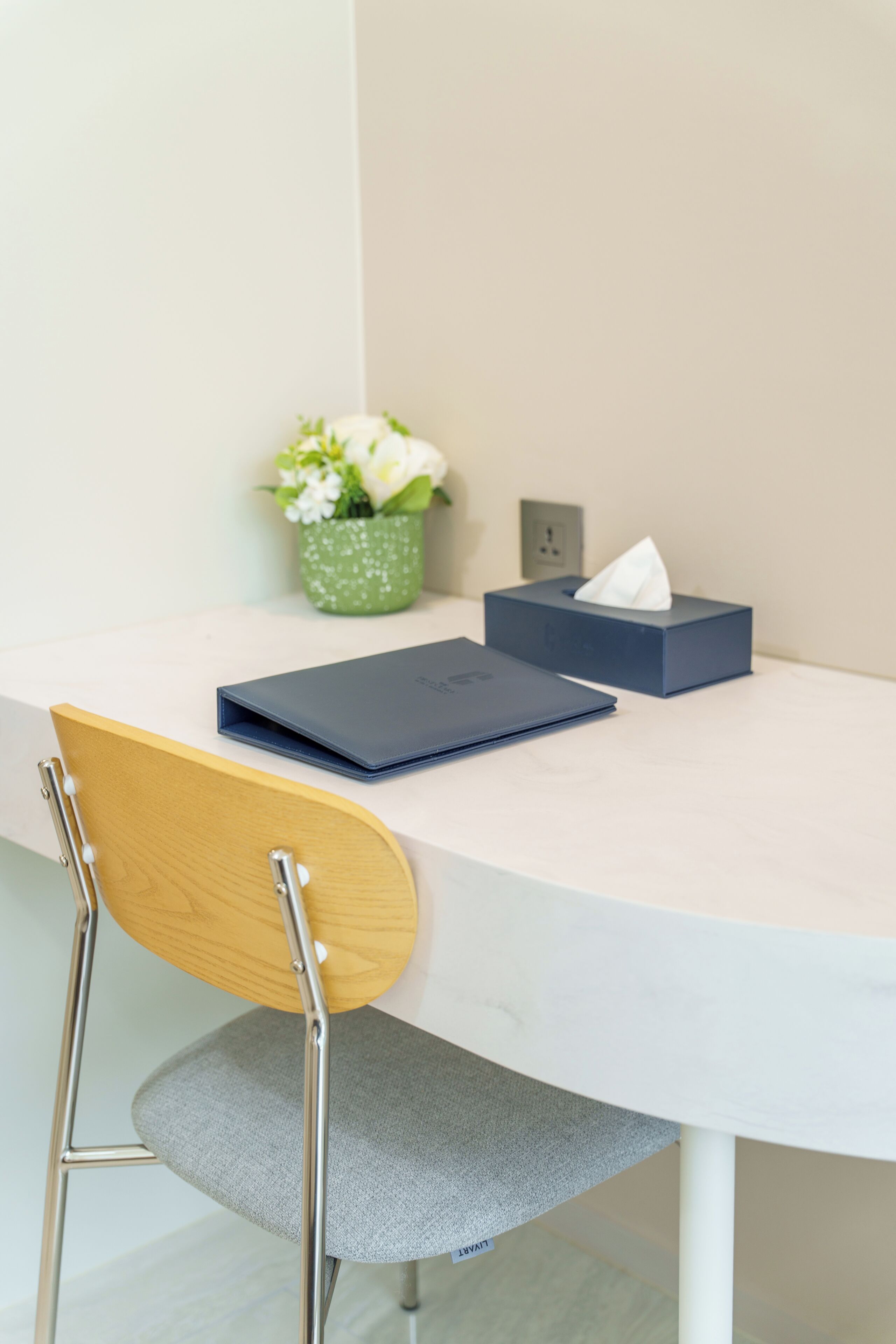 A round table with a notebook, a tissue box, and a potted plant.
