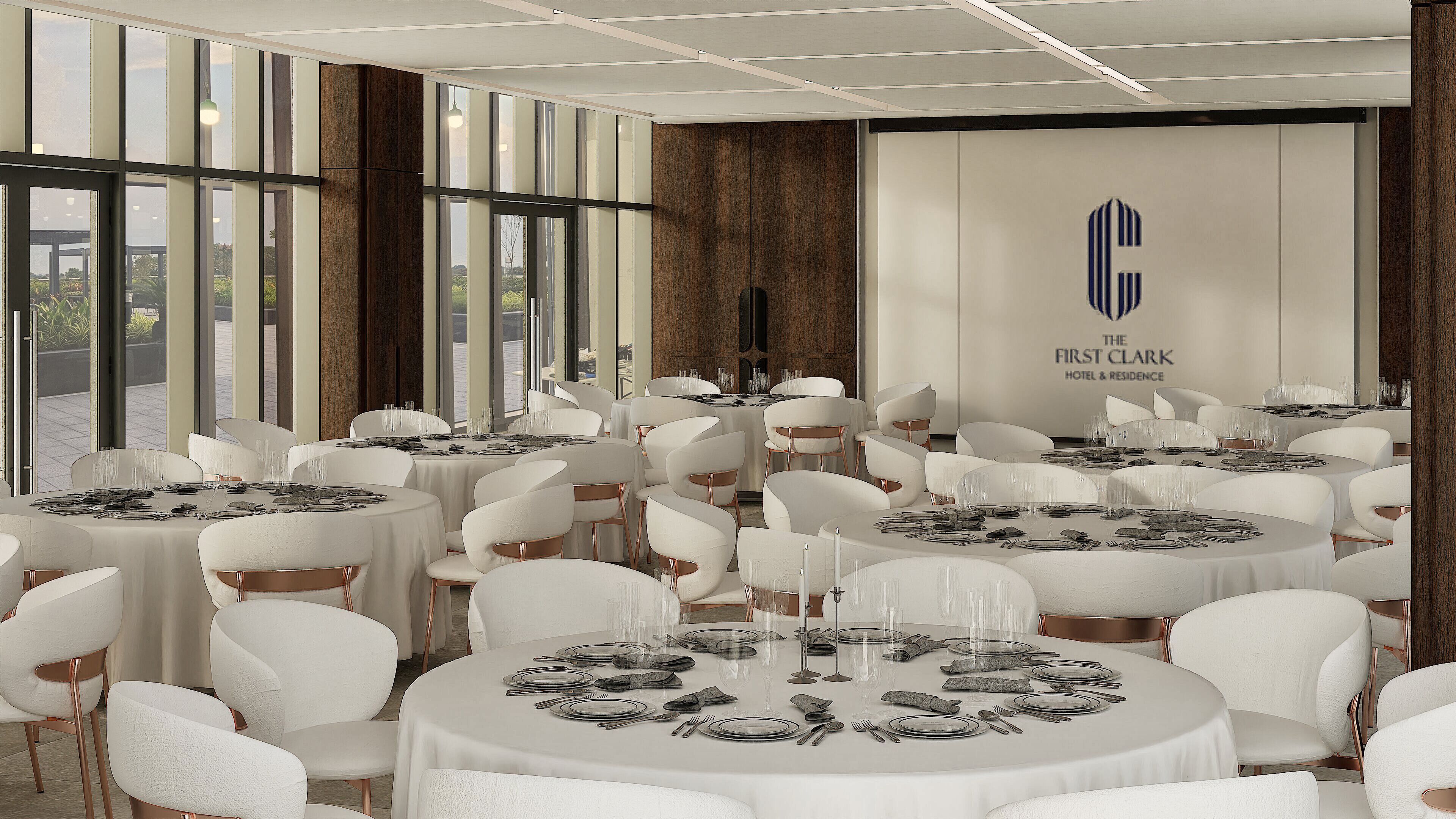A hotel dining area with round tables, white chairs, and a view of the outdoors through large windows.