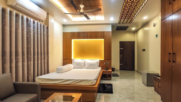 Een moderne hotelkamer met een groot bed, een bank, een salontafel en een kledingkast.