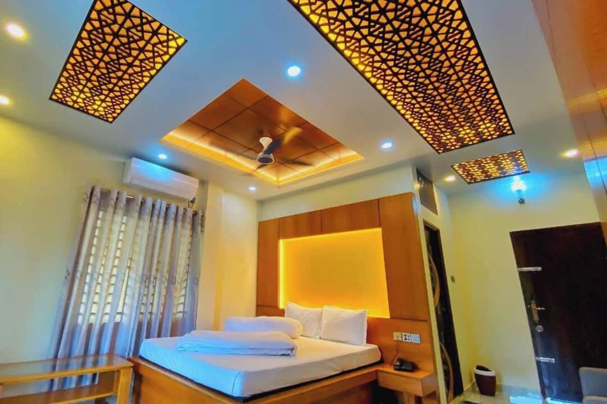 A modern hotel room with a bed, bedside table, and a ceiling fan.