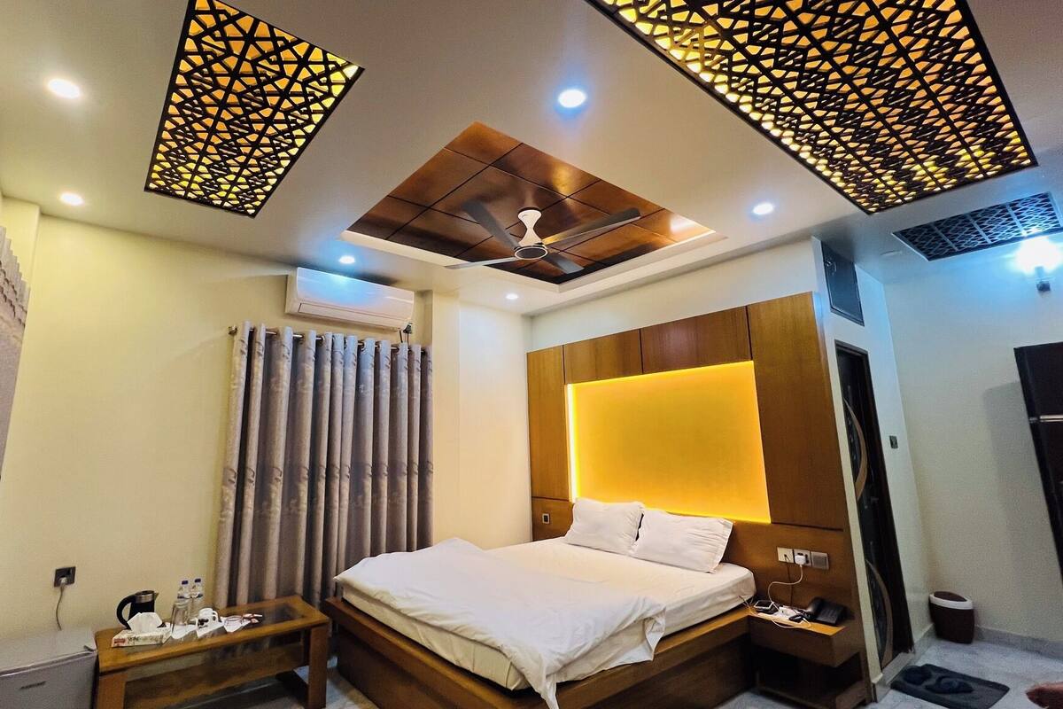 A modern hotel room with a bed, bedside table, and a ceiling fan.