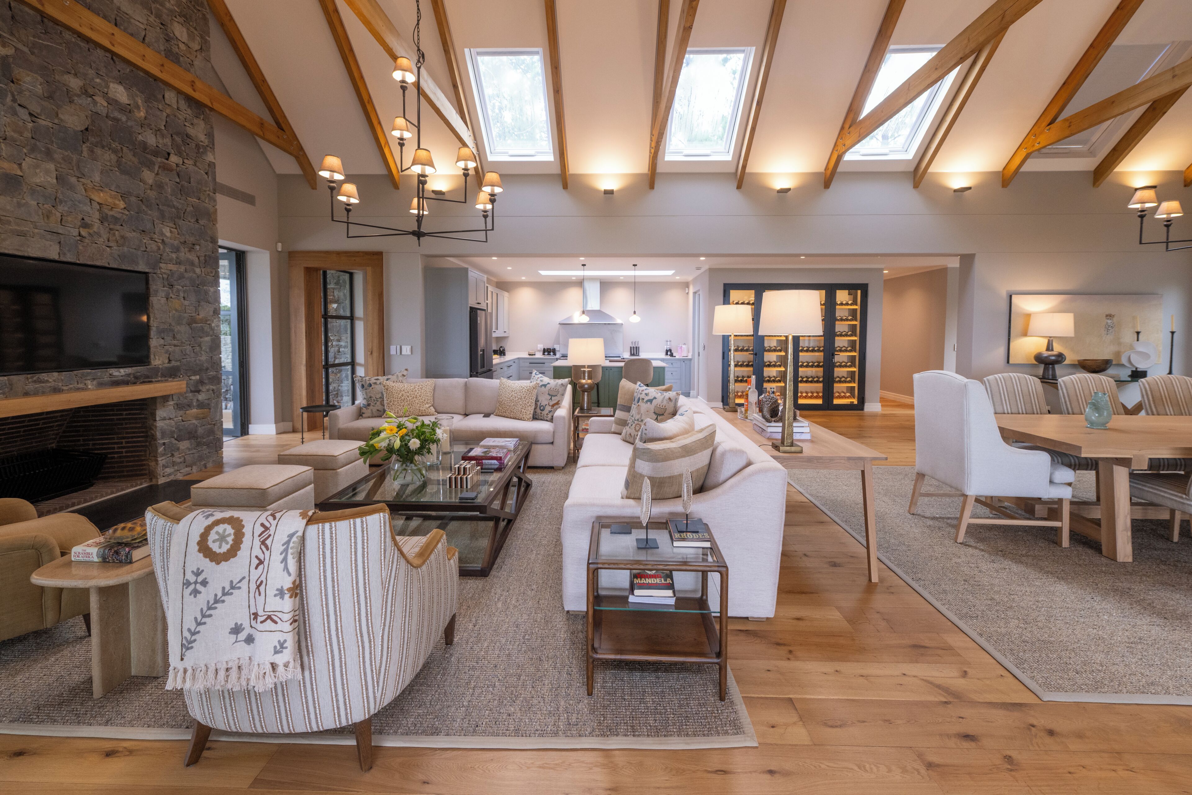A spacious living area with a fireplace, sofas, a coffee table, and a dining area with a table and chairs.
