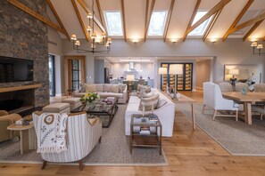 A spacious living area with a fireplace, sofas, a coffee table, and a dining area with a table and chairs. - Brookdale Estate - Manor House (Cape Town)