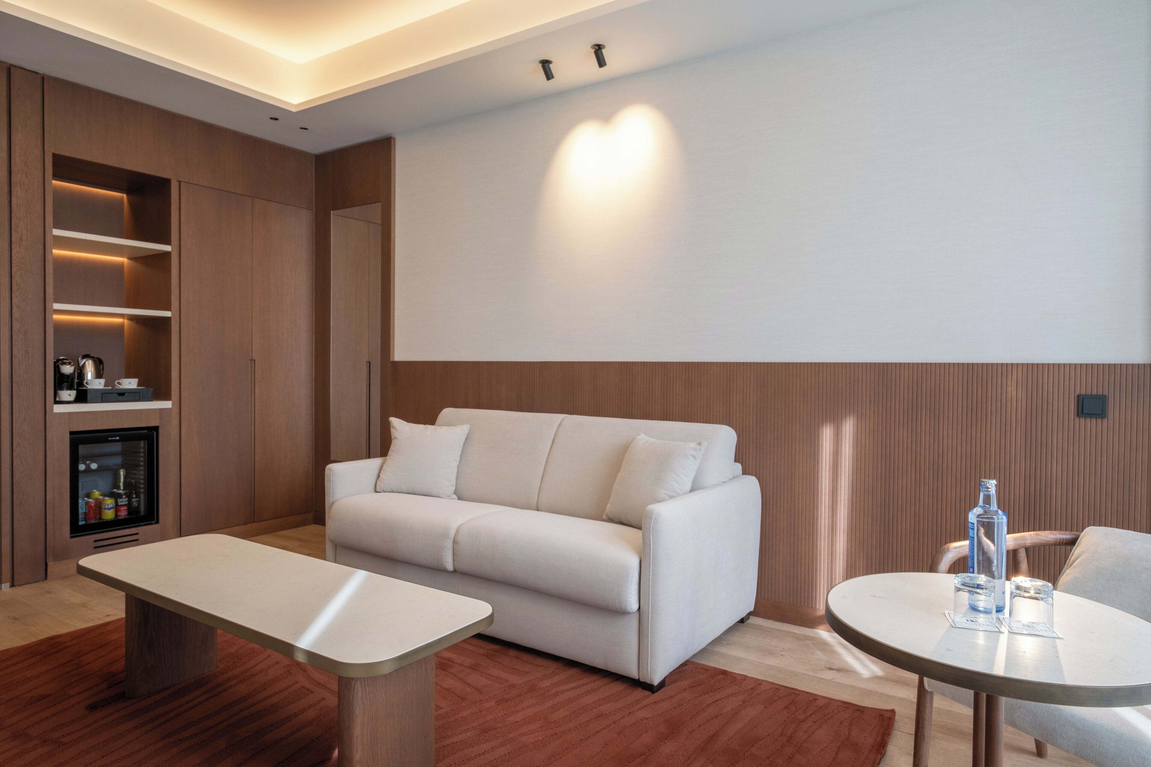 A modern living room with a sofa, a coffee table, a TV, and a built-in entertainment unit.