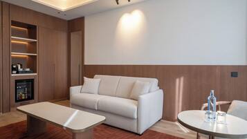 Un salon moderne comprenant un canapé, une table basse, un téléviseur et un meuble de rangement intégré pour les appareils multimédias.