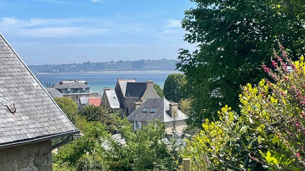 A coastal view with houses, a wooden fence, and a grassy area. - Ker Levenez - Stone house Perros-Guirec (Perros-Guirec)