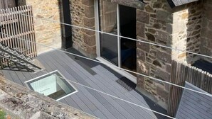 A stone house with a sloped roof, a small window, and a wooden deck. - Ker Levenez - Stone house Perros-Guirec (Perros-Guirec)