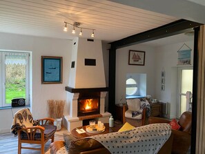 Un salón acogedor con chimenea, muebles de madera y vistas al exterior.