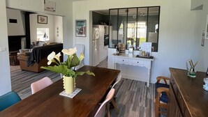 Una cocina moderna con armarios blancos, horno empotrado y un amplio ventanal.