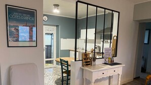 Un baño moderno con un espejo grande, un tocador blanco y una silla de madera.