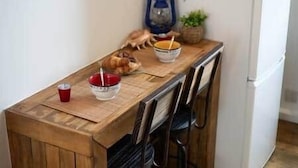 A wooden dining table with a red cup, a bowl with a spoon, and a blue lantern. - Gevelled, Town house Perros (Perros-Guirec)