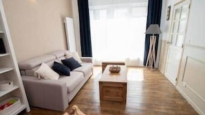 A living room with a sofa, a coffee table, and a lamp. - Gevelled, Town house Perros (Perros-Guirec)