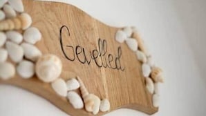 A wooden sign with the word "Gevled" surrounded by white pebbles. - Gevelled, Town house Perros (Perros-Guirec)