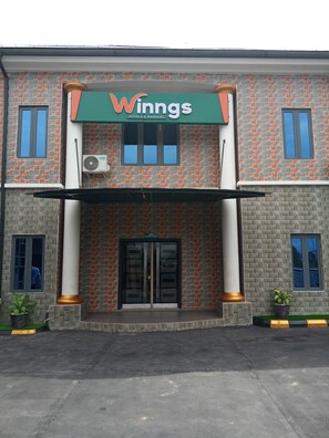 A building with a sign reading "Winngs Hotels & Banquet" and an "Event Hall" sign above the entrance. - Wiings Hotel & Banquet (Uyo)