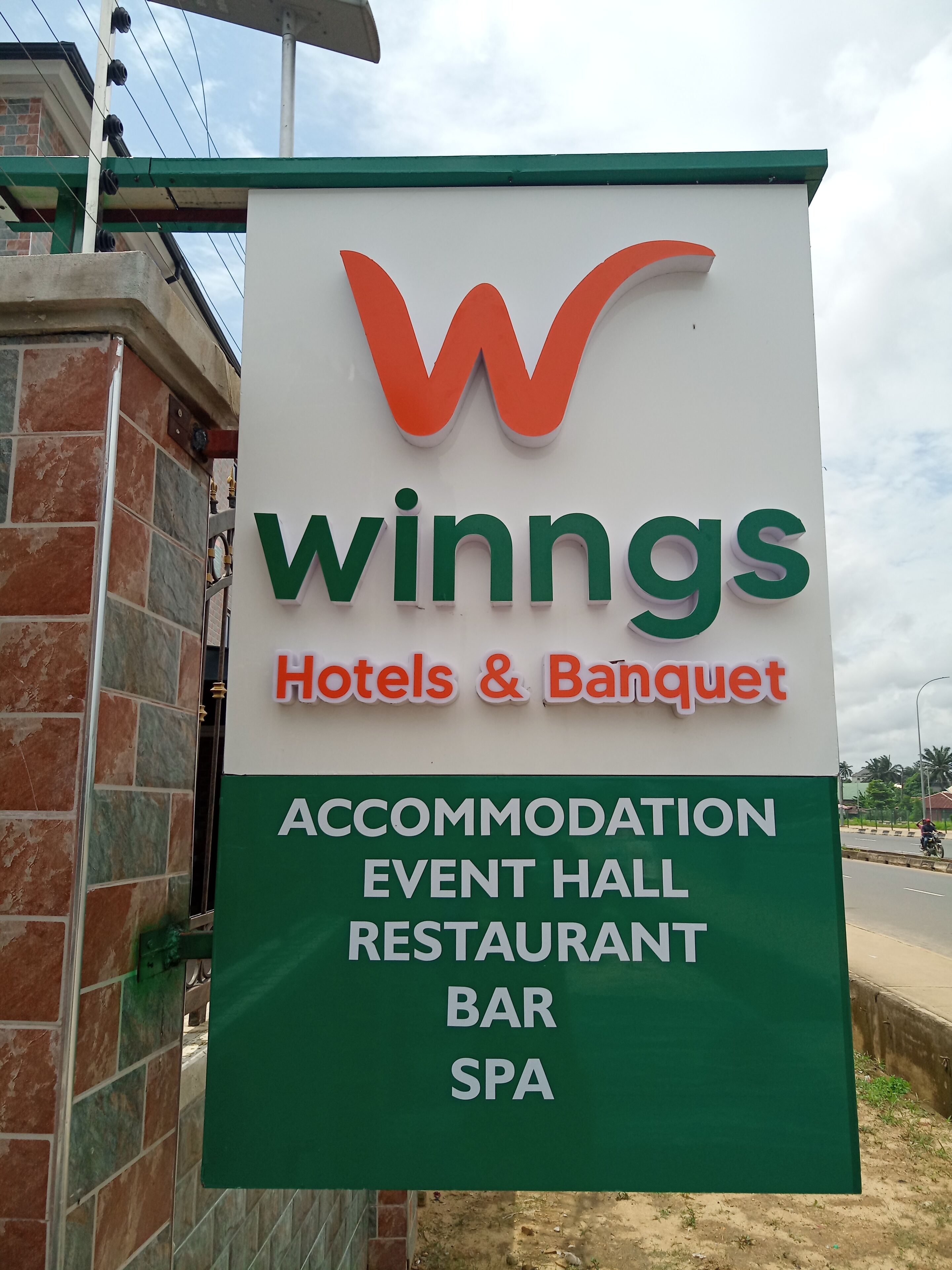 A sign for 'Winings Hotels & Banquet' advertising accommodation, event hall, restaurant, bar, and spa services.