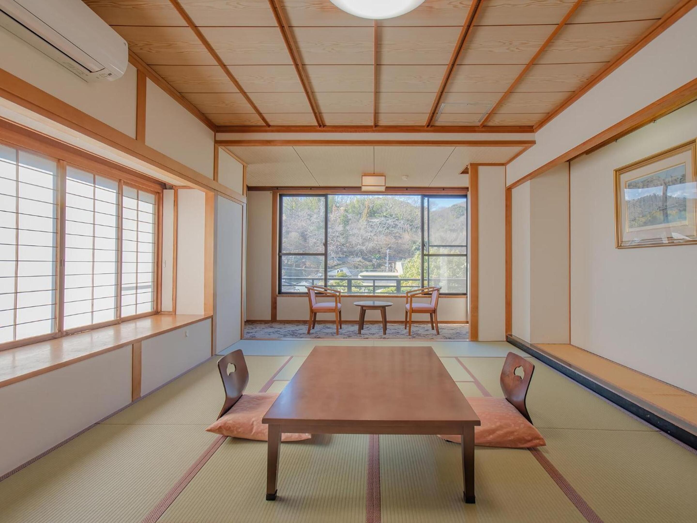 Una habitación japonesa tradicional con suelo de tatami, una mesa baja y puertas correderas.