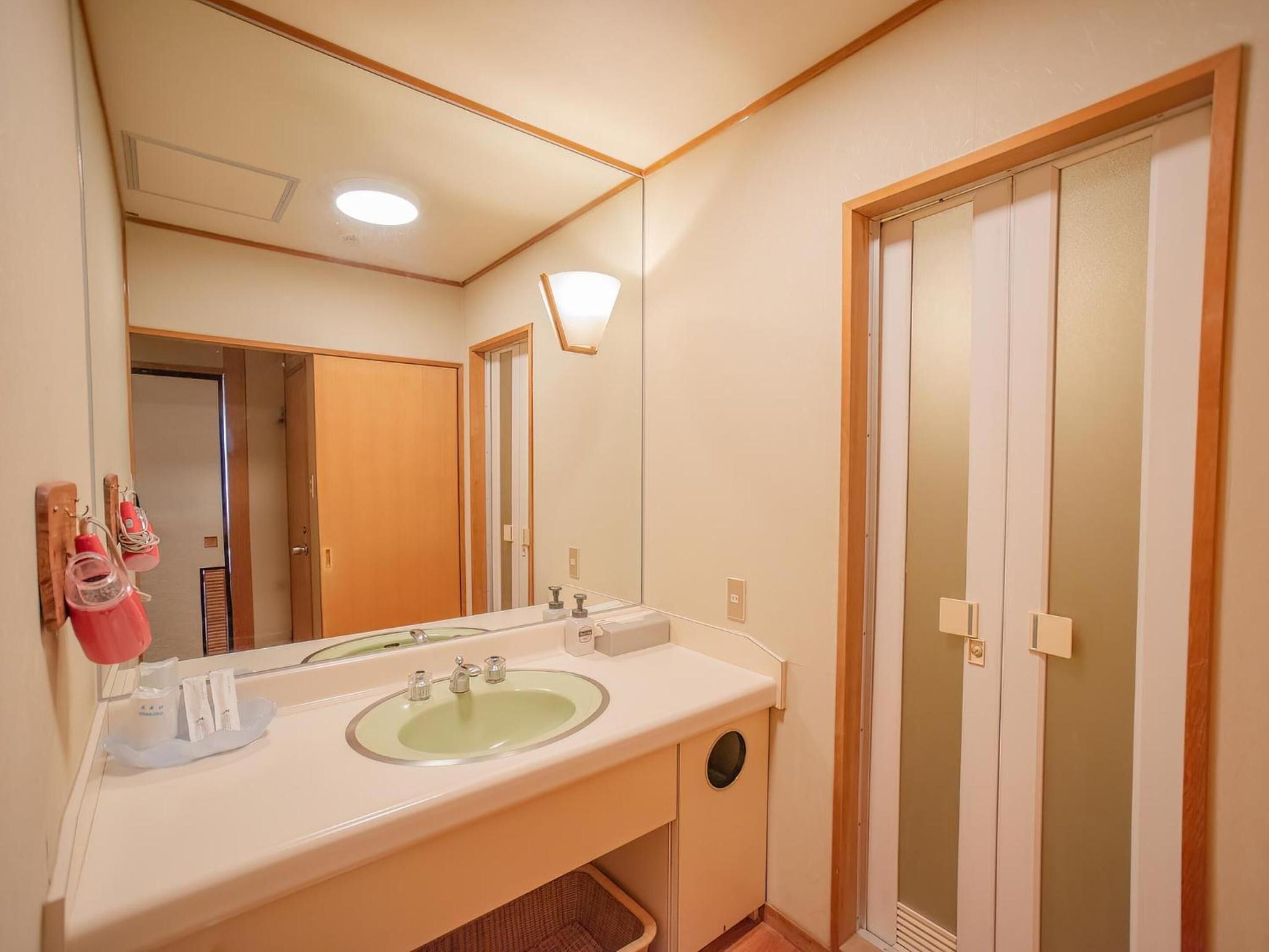 Un baño con lavamanos doble, un espejo y un inodoro.