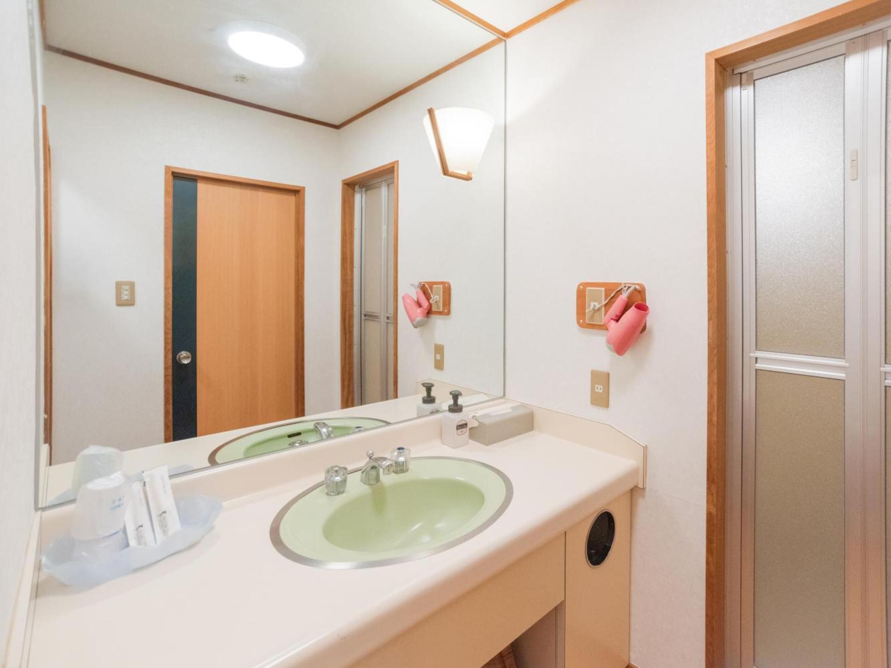 A bathroom with a large mirror, two sinks, and a towel rack with towels.