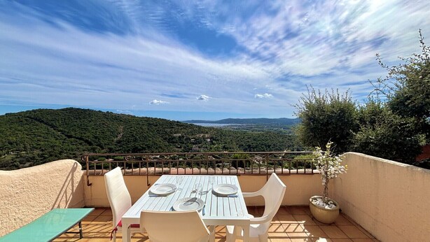 Eine Terrasse mit Tisch für zwei Personen, mit Blick auf eine malerische Landschaft.