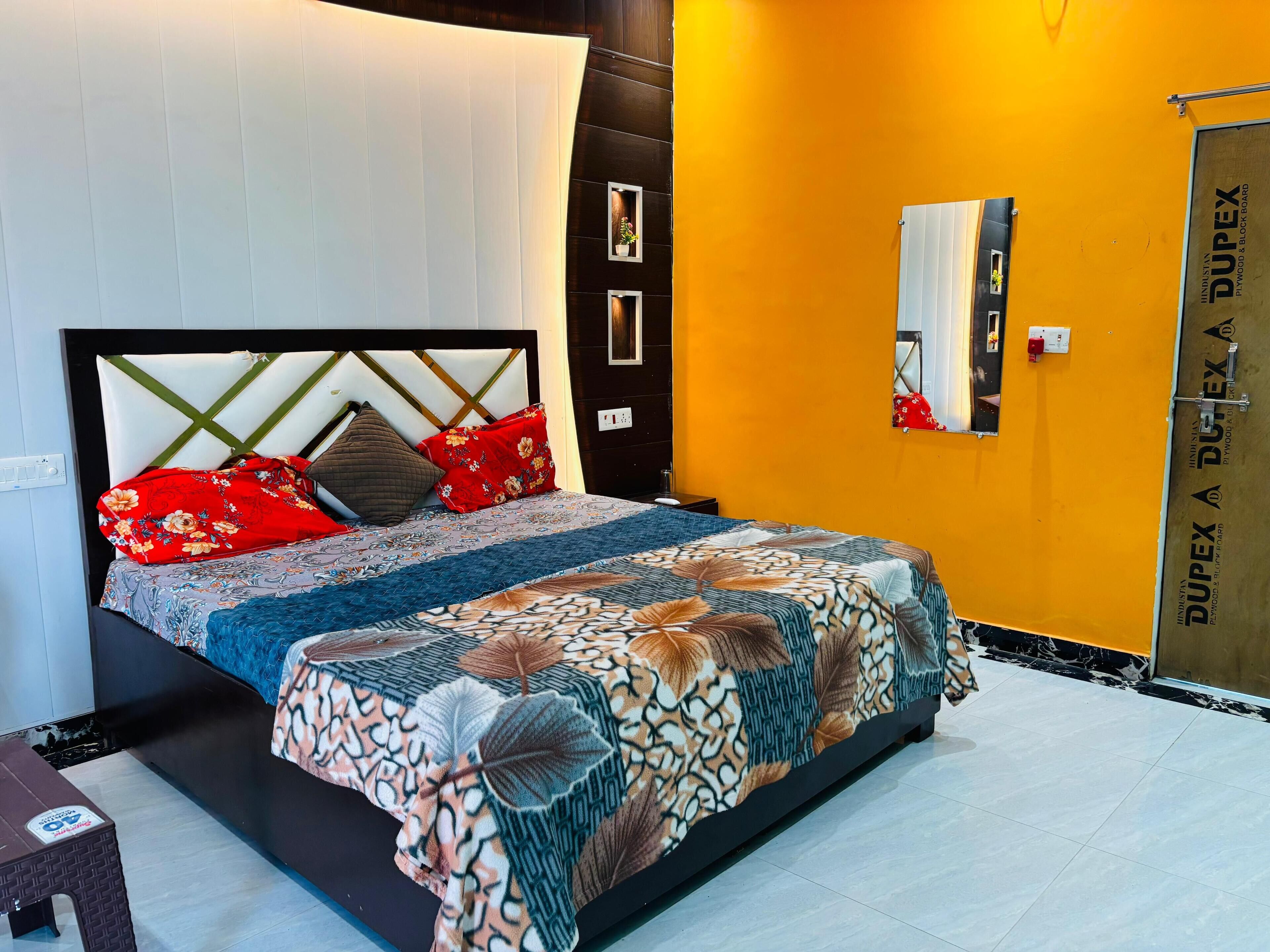 A bed with a patterned bedspread, a headboard with a geometric design, and multiple pillows.