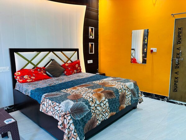 A bed with a patterned bedspread, a headboard with a geometric design, and multiple pillows.