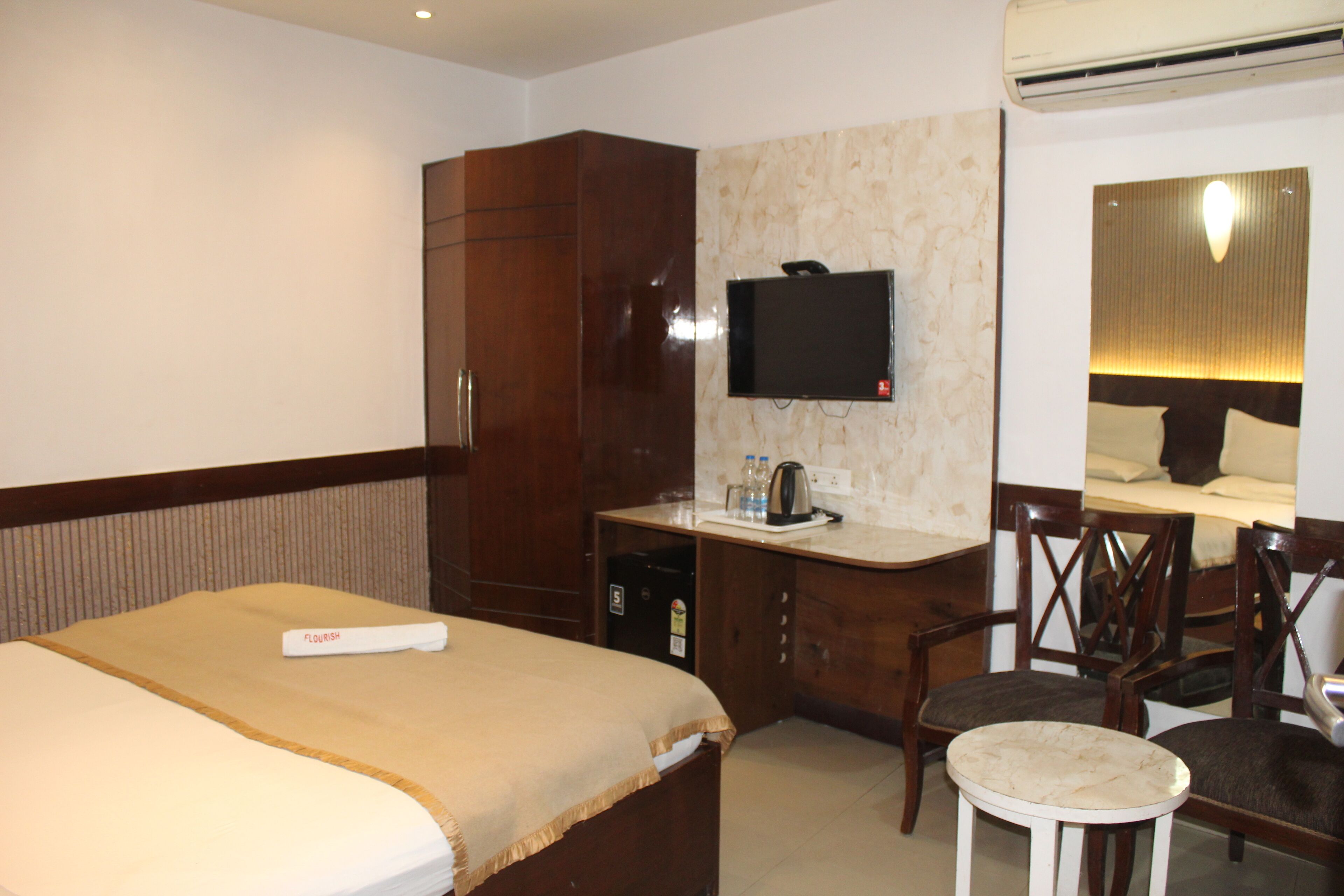 A hotel room with a bed, a desk, a television, and a chair.
