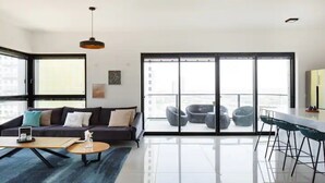 A modern living room with a sofa, coffee table, and large windows. - Special Apartment Sea View Luxury Tower (Bat Yam)