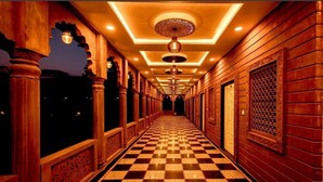 A corridor with checkered flooring, wooden paneling, and decorative ceiling lights. - Umraogarh A Unit of Raghav Vilas (Jodhpur)