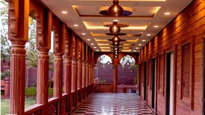 A corridor with wooden columns and a checkered floor, leading to a staircase. - Umraogarh A Unit of Raghav Vilas (Jodhpur)