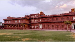 A large, red-brick building with multiple arches and a central courtyard. - Umraogarh A Unit of Raghav Vilas (Jodhpur)