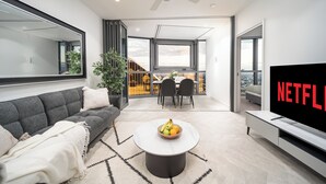 Een moderne woonkamer met een bank, salontafel en televisie.