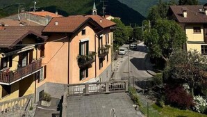 Un quartier résidentiel avec des immeubles, une rue et des montagnes en arrière-plan.