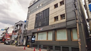 A multi-story building with a large window display and signage for a jewelry store. - The Mayberry A Bergamont Hotel Tiruppur (Tirupur)