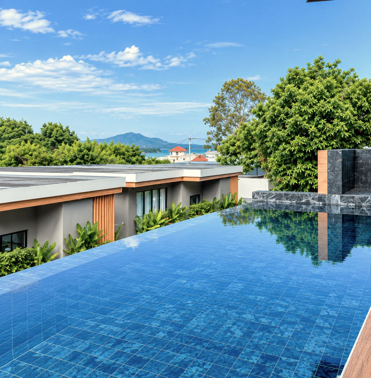 Ein moderner Infinity-Pool mit freiem Blick auf das Meer und die dahinterliegenden Berge.