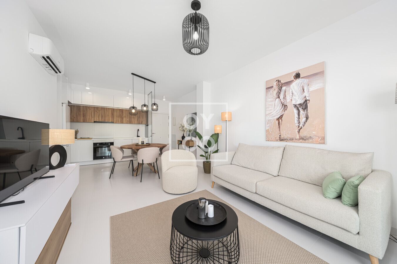Een moderne woonkamer met een bank, een eettafel en een keuken op de achtergrond.