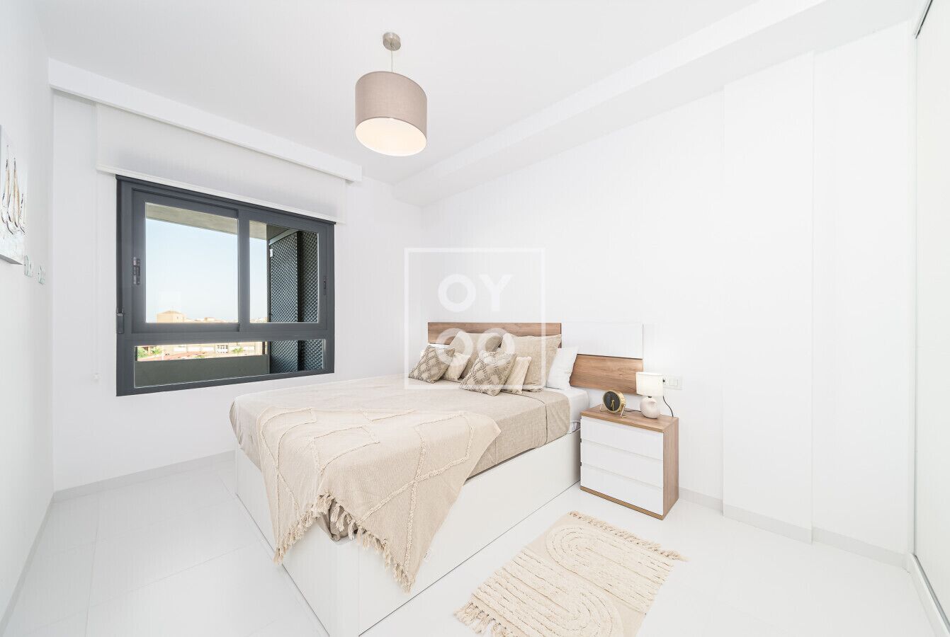 Ein modernes Schlafzimmer mit Bett, Nachttisch und einem Fenster mit Jalousien.