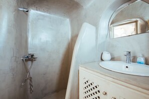 A bathroom with a shower, a sink, and a mirror.