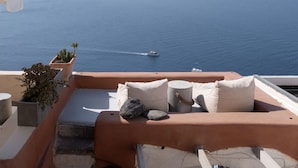 A terrace with a view of the sea and distant mountains.