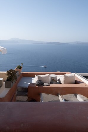 A terrace with a view of the sea and distant mountains.