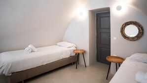 A bedroom with a bed, a small table, a mirror, and a door.