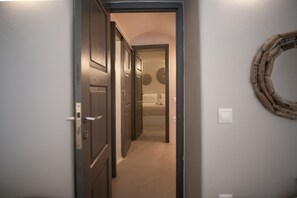 Een gang die leidt naar een slaapkamer met een ronde wanddecoratie.