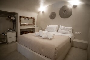 Une chambre à coucher avec un grand lit, une table de chevet, une commode, un miroir et un luminaire fixé au mur.
