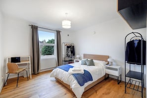2 habitaciones, escritorio y tabla de planchar con plancha