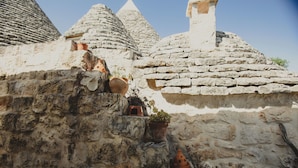 Un bâtiment en pierre, doté de toits coniques et orné de pots en terre cuite.